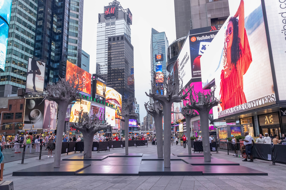 View of sculptures of upside-down trees showing only their trunks and roots in Times Square. 
