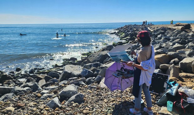Larisa Anaya of Georgetown, Texas uses watercolors to paint the seascape near Capitola Village at the plein air quick paint competition Saturday. (Aric Sleeper/Santa Cruz Sentinel)