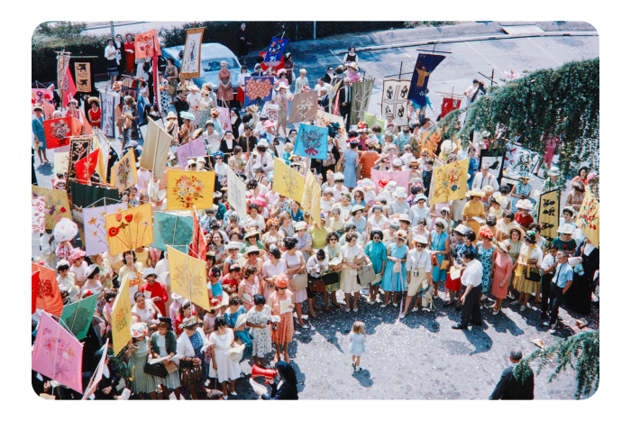 An overhead shot of brightly dressed women gathering in the sunshine for the annual Mary’s Day parade 