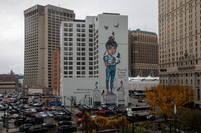 A giant mural of a girl surrounded by birds over a Detroit parking lot on Wednesday, Nov. 8, 2023. Mural by Australian artist Smug.
(Credit: David Rodriguez Munoz, Detroit Free Press)