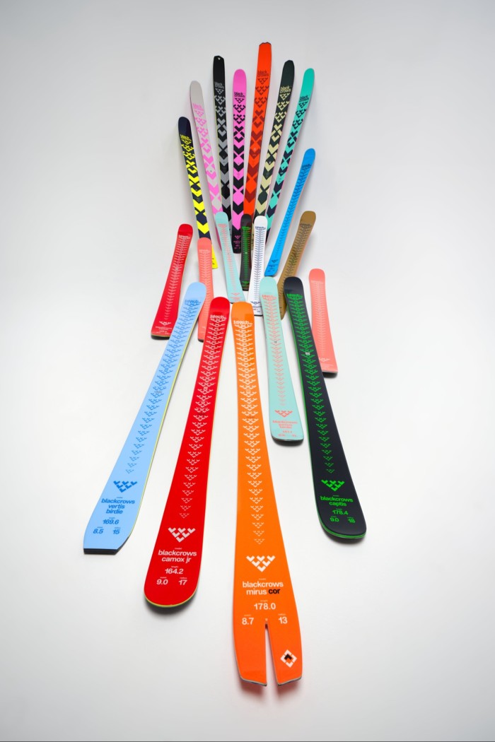 Pairs of brightly coloured skis laid out on the ground