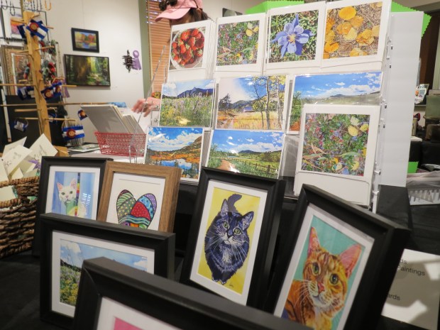 Dori Stickles, Louisville Art Association board member, sells prints of the watercolor paintings at the Fall Member Show and Sale.(Andrea Grajeda/ Staff Writer)