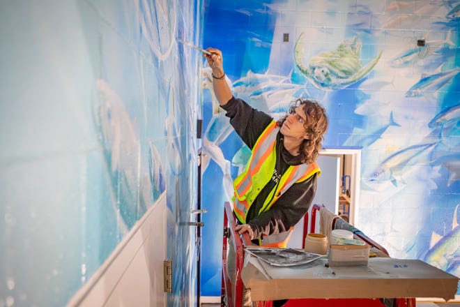 Muralist Esteban Camacho Steffensen work on a mural he has spent three months painting in the aquatic center at the new Eugene Family YMCA. Camacho Steffensen was responsible for a 2005 mural in the aquatic center at the Patterson Street YMCA.