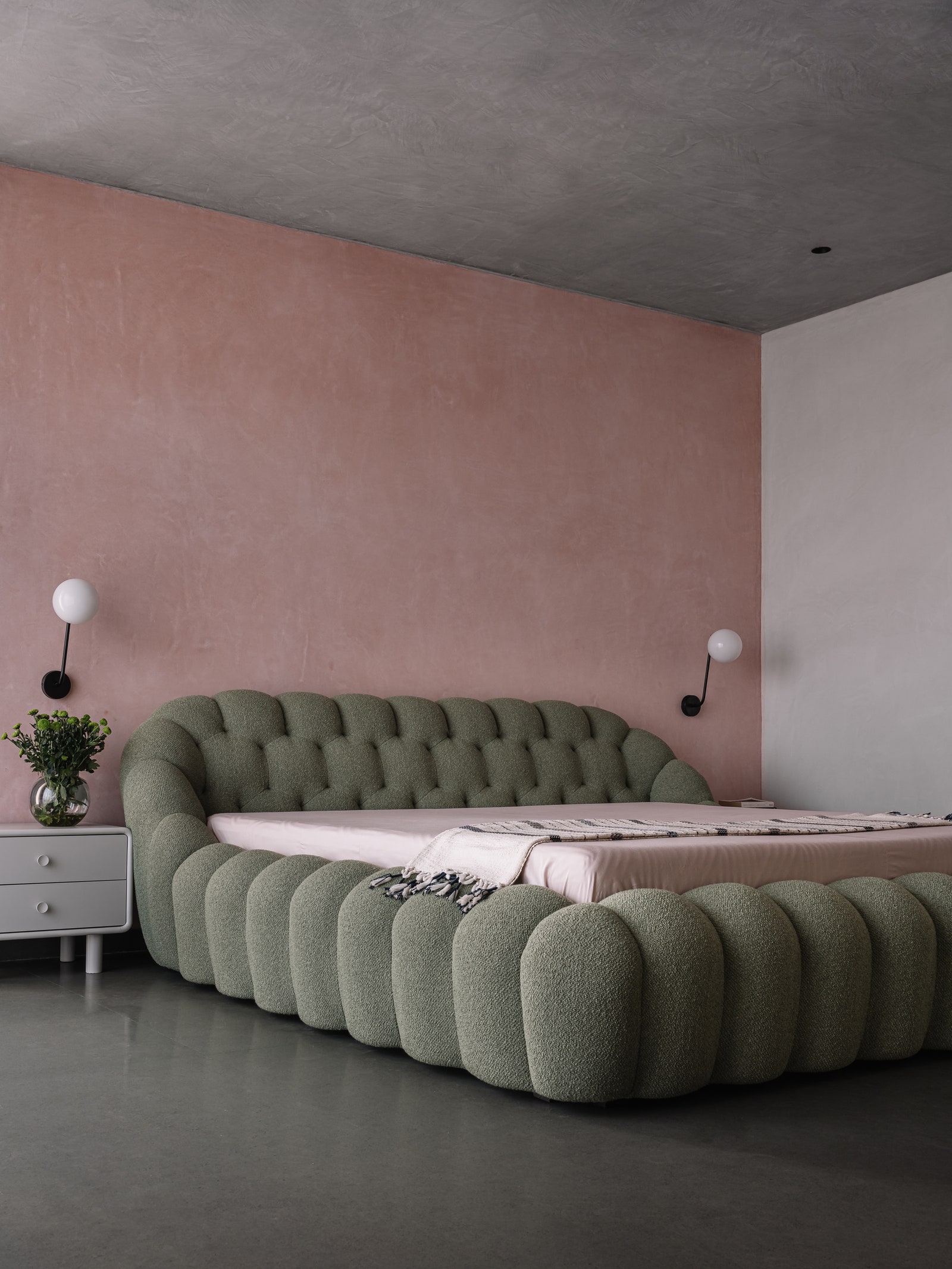 Set against a dusty rose backdrop a sage green Roche Bobois bubble bed commands all the attention in the primary...