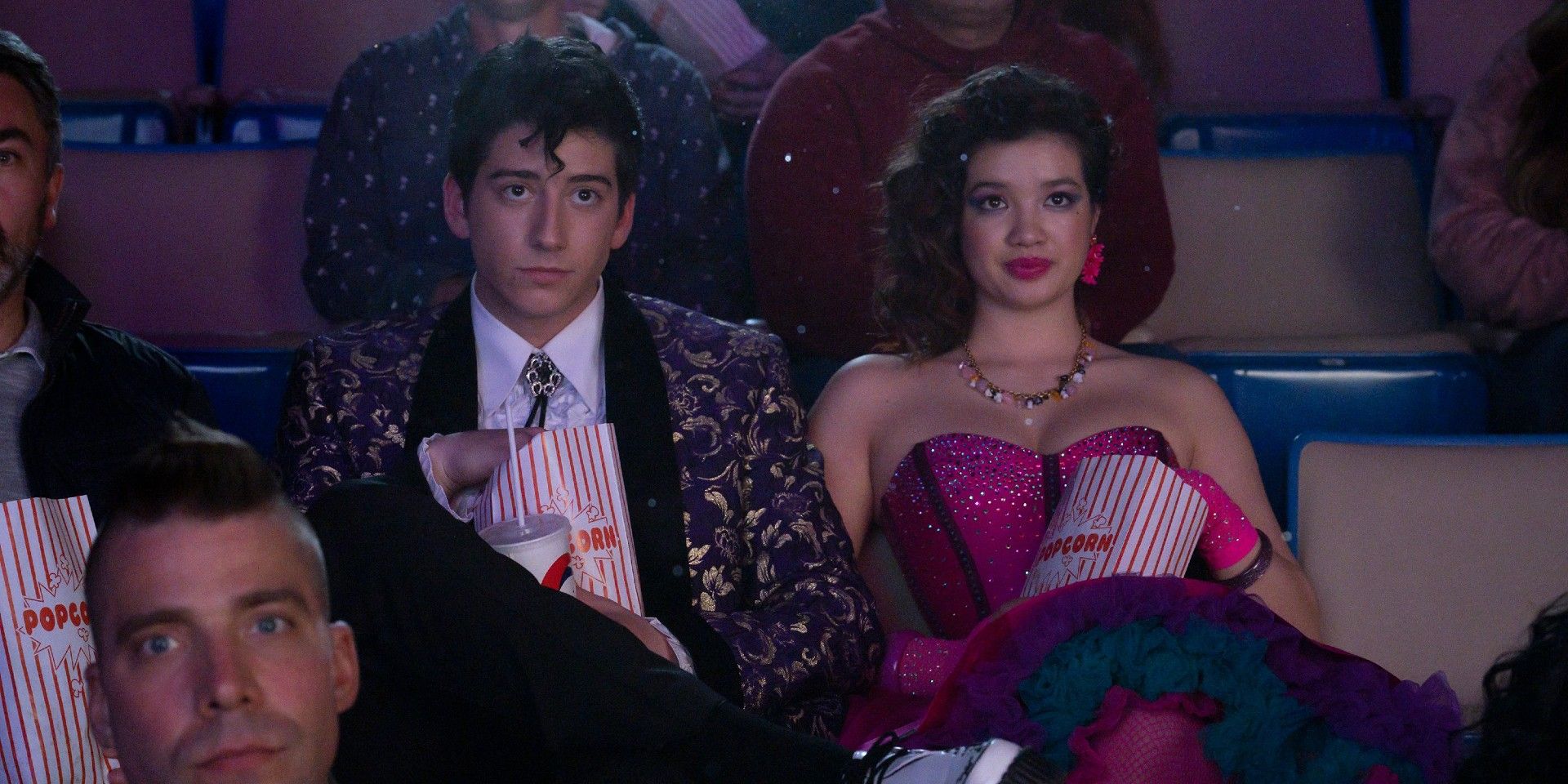 A couple sitting in a movie theater eating popcorn in Prom Pact