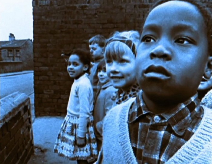 A group of children stand together in an urban setting