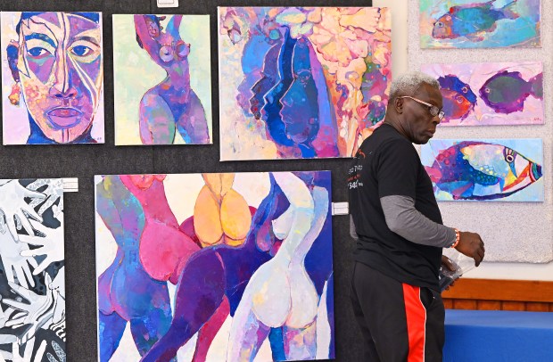 Artist Wilfred Obinyan sets up his art work with One People Tribe at the Nirman King Center during Vallejo Open Studios on Saturday. (Chris Riley/Times-Herald)