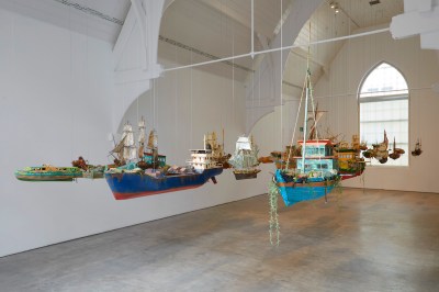 A group of suspended models of ships in a gallery.