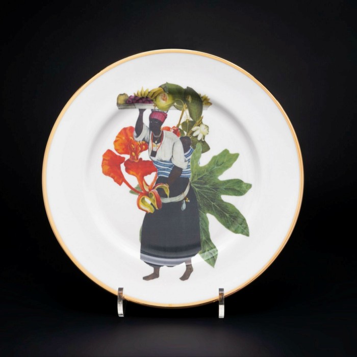 Two white plates painted with black people among flora and fauna