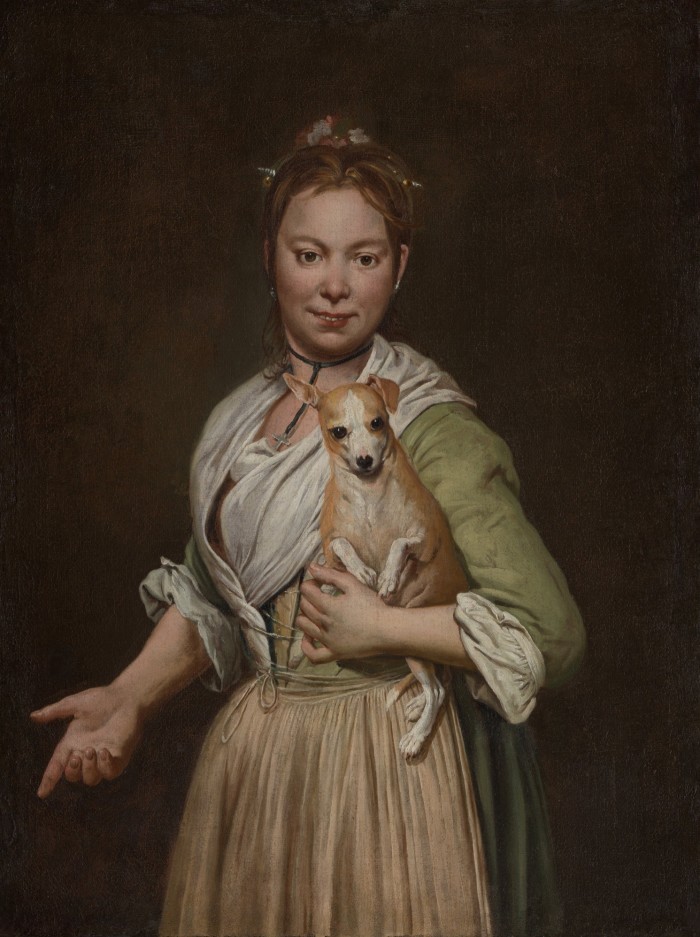 Portrait of a young woman in a dress holding a puppy