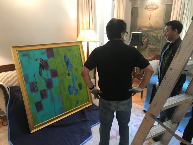 Mario Castillo and San Angelo artist René Alvarado discuss where to hang a painting in the European Union residence on May 15, 2019.
