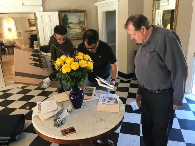 Left to right: San Angelo artist René Alvarado, Mario Castillo, and San Angelo Museum of Fine Arts Director Howard Taylor review plans on where to place 36 pieces of Texas art inside the European Union residence on May 15, 2019.