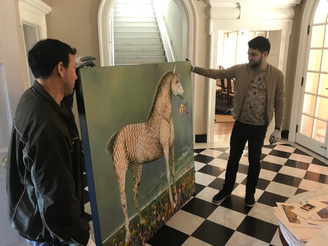 San Angelo artist René Alvarado and Taylor Velarde carry in a one of Alvarado's paintings  to be installed in the European Union residence on May 15, 2019.