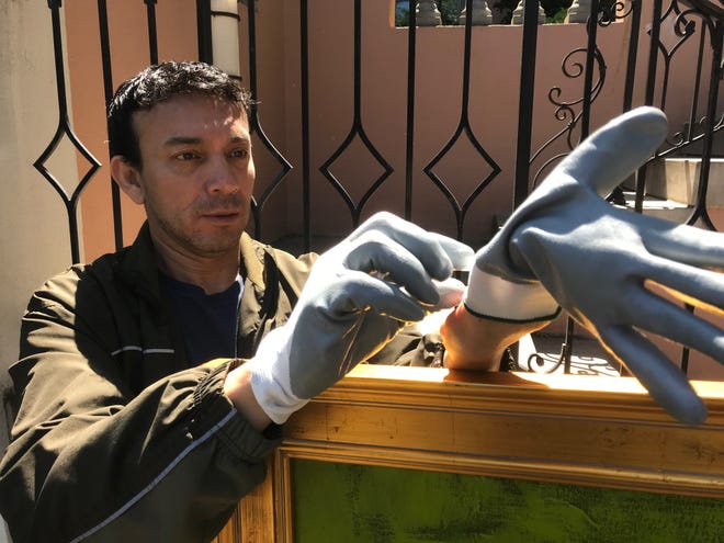 San Angelo artist René Alvarado puts on special gloves before picking up art to be installed in the European Union May 15, 2019.