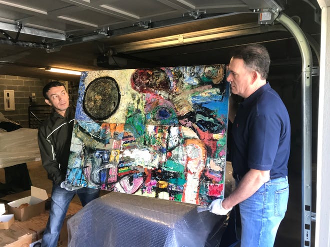 San Angelo artist René Alvarado and SAMFA board member Jeff Curry pick up a painting to be installed in the European  Union residence on May 15, 2019.