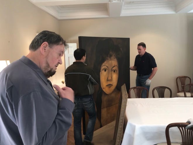 San Angelo Museum of Fine Arts Director Howard Taylor advises René Alvarado and Jeff Curry on where to hang a painting in the European Union residence, May 15, 2019.