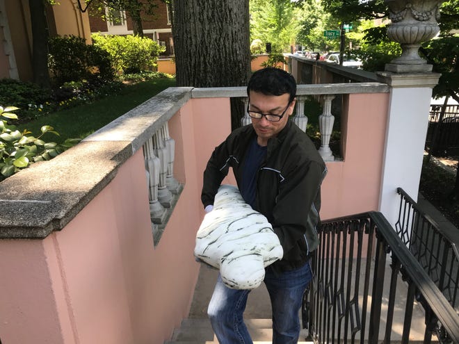 San Angelo artist René Alvarado carries in a stoneware sculpture to be installed in the European Union on May 15, 2019.
