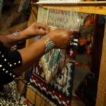 Vivian Descheny working on a small rug involving five separate patterns and 40 colors. (Erin Cox, KSL TV) 