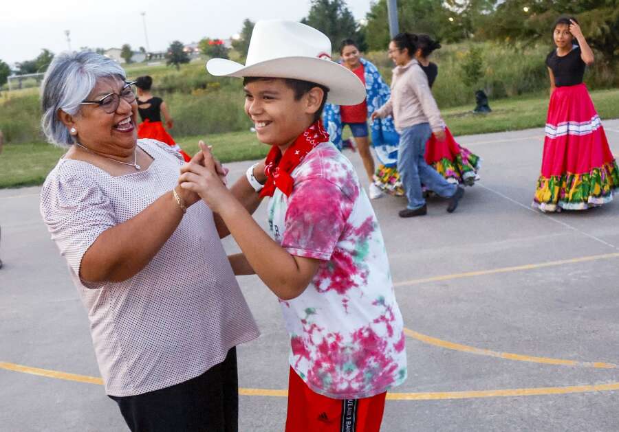 Monica Vallejo dances with Steve Lagunas during a Sept. 15, 2022, rehearsal of the Ballet Folklórico troupe  Fuerzas Culturales at Delaney Memorial Park in southwest Cedar Rapids. The city is seeking an artist or art team to create a full-court mural on the park’s basketball court.  (Jim Slosiarek/The Gazette)