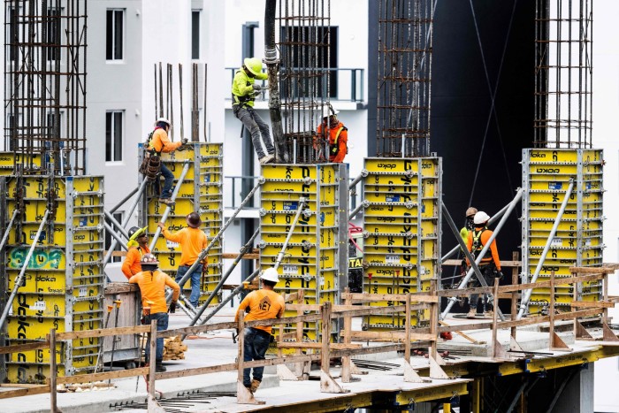 Construction workers erect a building in downtown Miami, Florida, in June