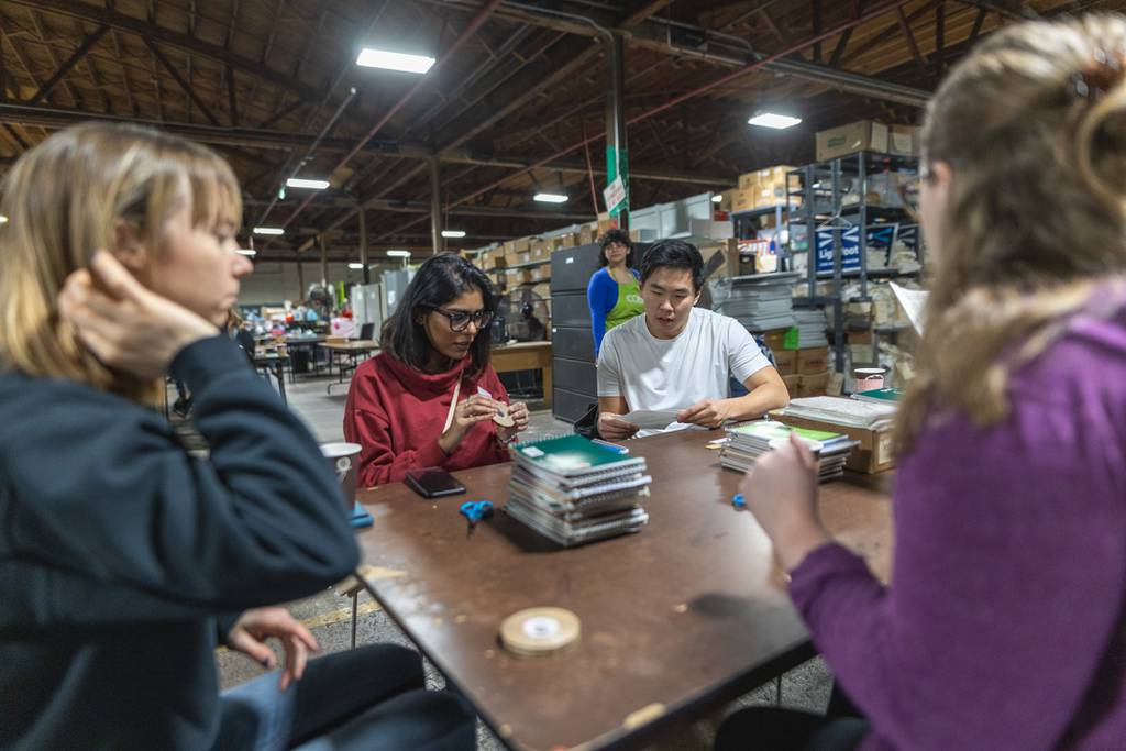 Volunteers Soo Choe and Meeker Munir make creative reuse notebooks for the group Young Chicago Authors’ upcoming “Rooted in Radical” festival at the Creative Chicago Reuse Exchange warehouse on Jan. 20, 2024.