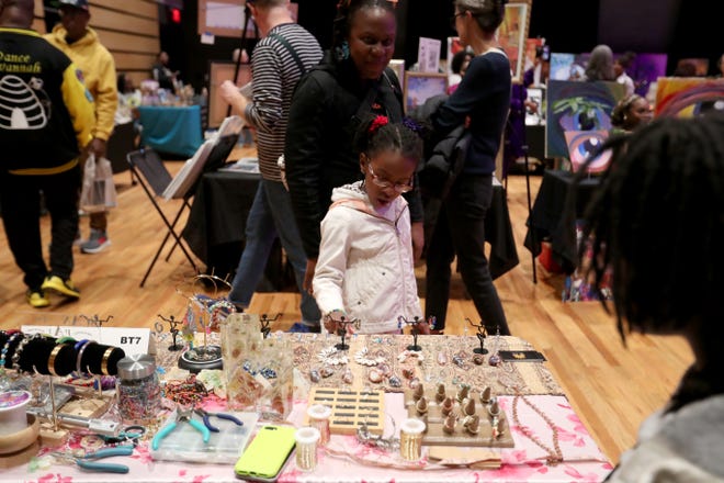 A young shopper looks through the items at the Nun-Fula: Guardians of the Culture booth during the 2nd annual Savannah Black Art Expo on Saturday, February 3, 2024 at the Savannah Cultural Arts Center.