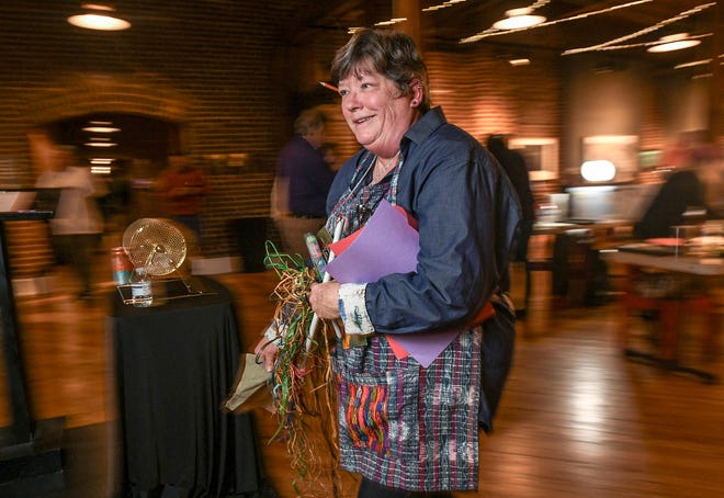 Patti Benjamin returns to her table after picking out art media from a table during the 2024 Art Slam! at Anderson Arts Center Friday, February 9, 2024.