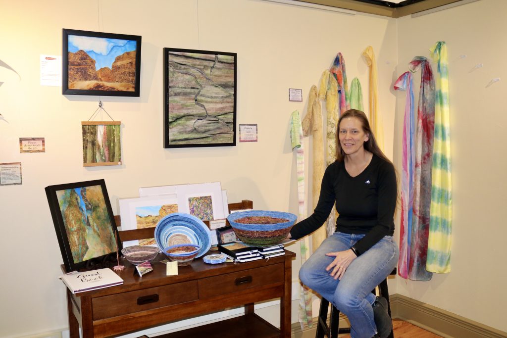 Textile Artist Teri McHale sits next to her artwork inside the Arrowhead Gallery in St. George, Utah, Feb. 22, 2024 | Photo by Jessi Bang, St. George News