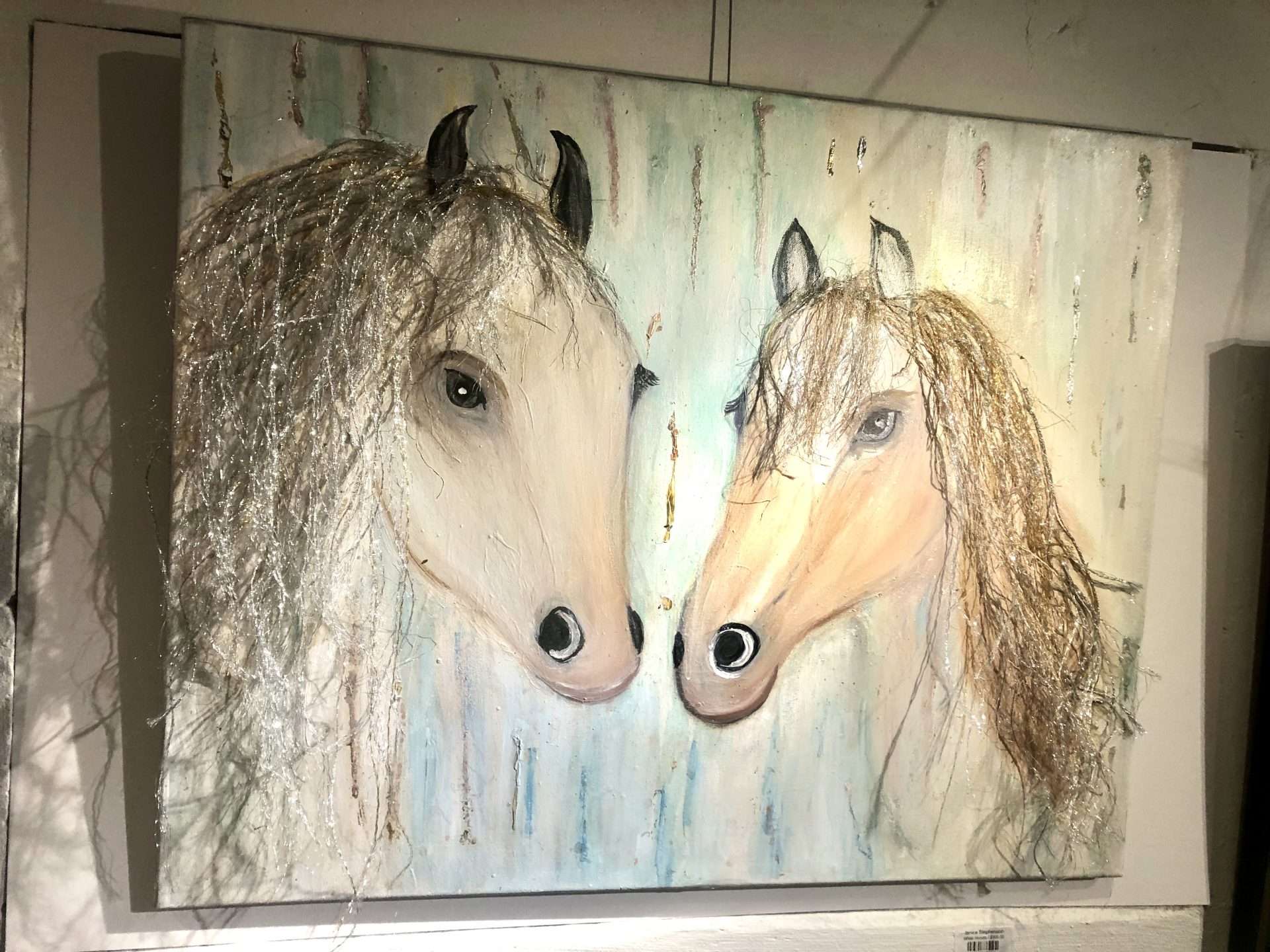 A painting showing two horses facing each other with fuzzy manes