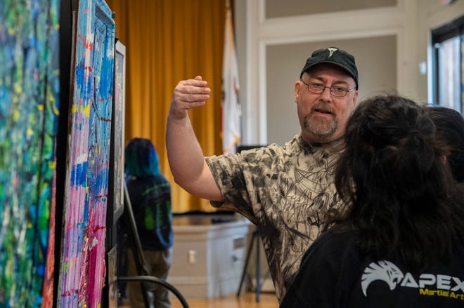 Artist Damon Gress talks with people about his work at the Stockton Arts Commission's inaugural Arts Night at the Stockton Memorial Civic Auditorium in downtown Stockton on Mar. 12, 2024. More arts nights are scheduled quarterly from 4:00 to 7:00 p.m on Jun. 5, Sept. 11 and Dec. 11. Artists and performers can apply for upcoming arts nights on the Stockton Arts Commission's page on the City of Stockton's website https://tinyurl.com/ynmxvaxh .