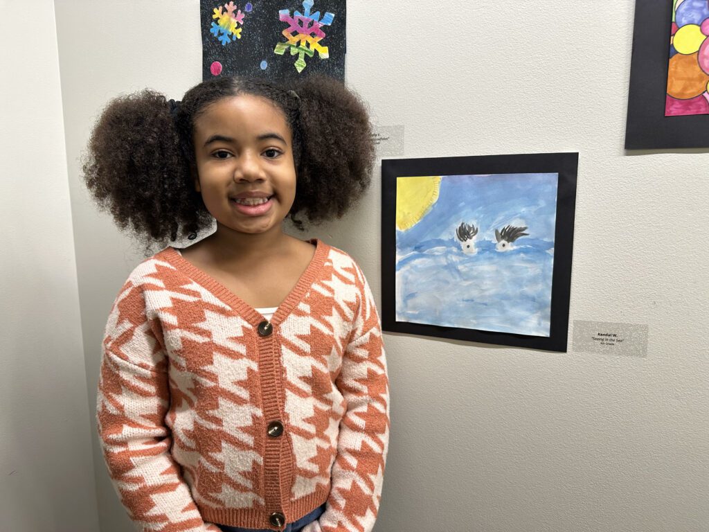 Artist Kendal Wilson poses with her art titled Seeing in the Sea at the Student Art Exhibi closing reception