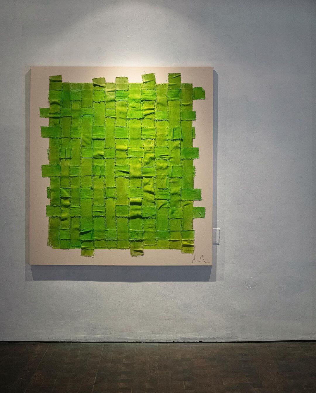 Textured green artwork by Laura Deems displayed on a white gallery wall.