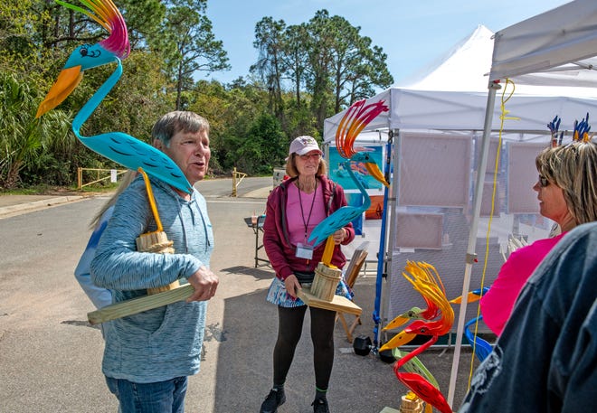 Artist Barbara Heinbaugh (center) sells her work during Gulf Breeze Celebrates the Arts Festival at the Gulf Breeze Parks & Recreation Community Center Sunday, March 24, 2024. The festival hosted 100+ local, regional and national artists, food vendors, a Local Artists Art Show, a Silent Auction as well as live artist demonstrations and children activities.