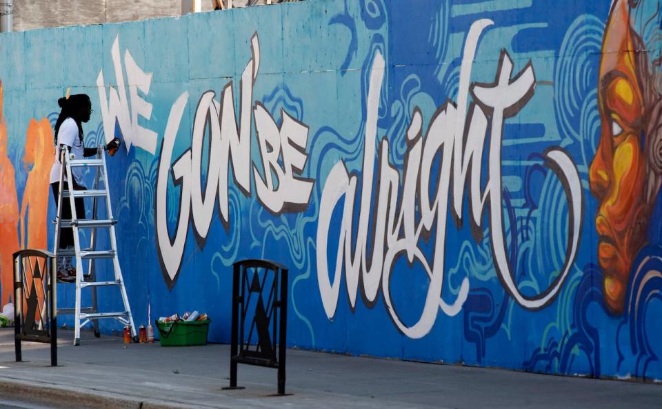 Artist Jimmy Baptiste works on a mural in Ottawa on July 10, 2020. The city's community services committee has passed a motion directing staff to examine poverty reduction strategies for local artists. (Adrian Wyld/The Canadian Press - image credit)