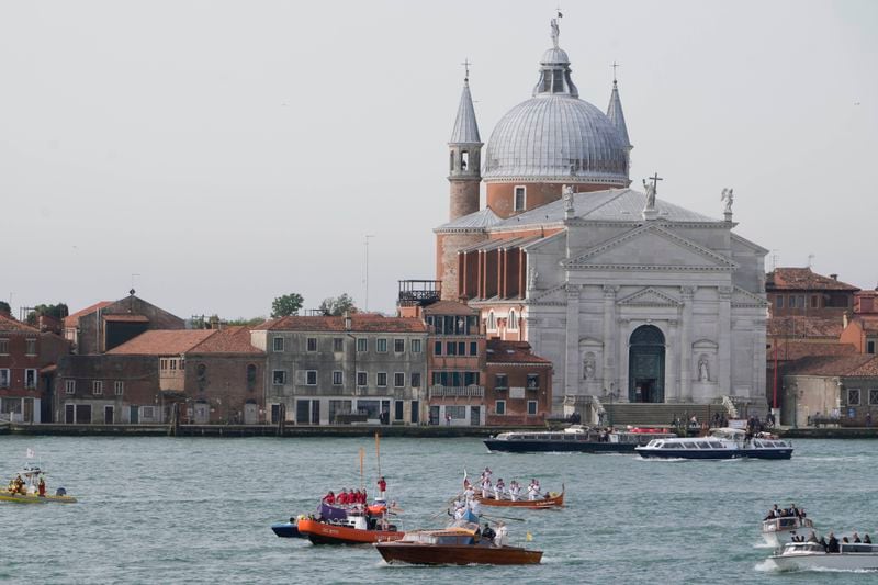 Pope Francis, foreground, is greeted by Gondoliers upon his arrival in Venice, Italy, Sunday, April 28, 2024. The Pontiff arrived for his first-ever visit to the lagoon town including the Vatican pavilion at the 60th Biennal of Arts. (AP Photo/Alessandra Tarantino)
