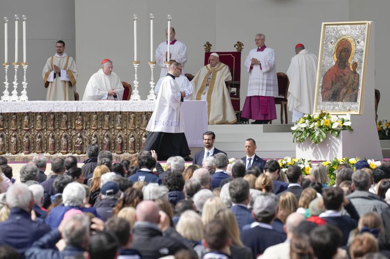 Pope Francis, background center, celebrates a mass in St. Mark's Square, Venice, Italy, Sunday, April 28, 2024. The Pontiff arrived for his first-ever visit to the lagoon town including the Vatican pavilion at the 60th Biennal of Arts. (AP Photo/Antonio Calanni)