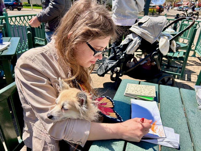 Kristen Lee, with her furry friend Barbara, sketches during Thursday's Urban Sketchers meeting.