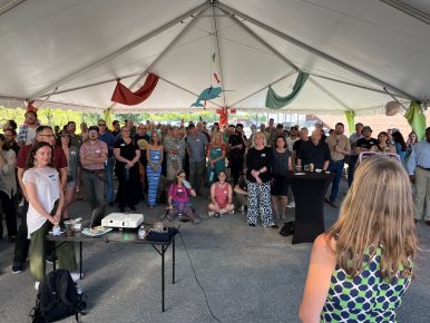 A crowd gathered under a tent.