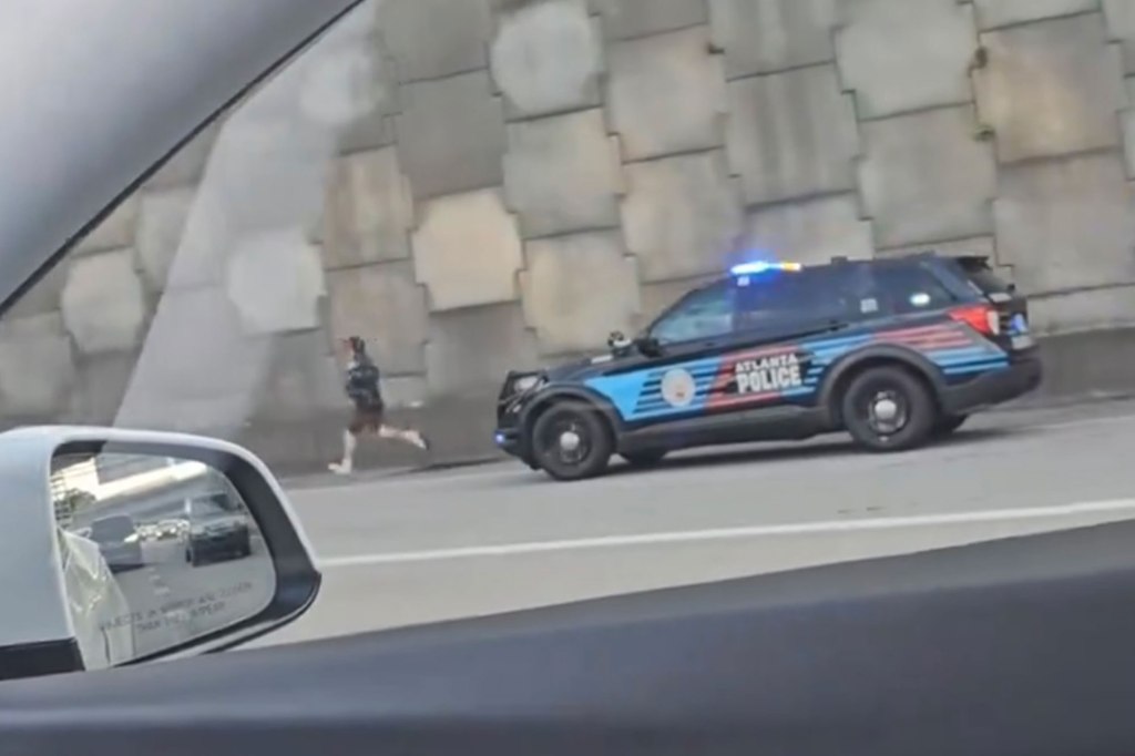 The man runs from the police car.