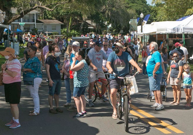 The area in front of the main stage at the Lakeland Public library is crowed as festival attendees stroll along Lake Morton Drive during the annual Mayfaire by-the Lake in Lakeland in 2021.