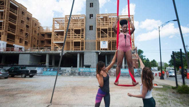 Lauren Hightower and Kait Graber with Maya Movement Arts give Kina Wilson of Charlotte an aerial arts demonstration during Artisphere in downtown Greenville on Friday, May 13, 2016.