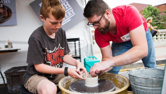 Gavin Stewart, 10, learns how to create a pot with the help of Mark Batory during Artisphere on Friday, May 12, 2017.