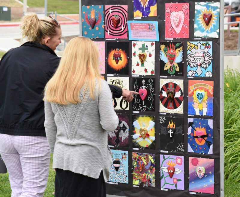 Attendees examine the artwork on display during the Day of Artist and Poet Festival at Bowman High School in Santa Clarita on Wednesday, 051524.  Dan Watson/The Signal