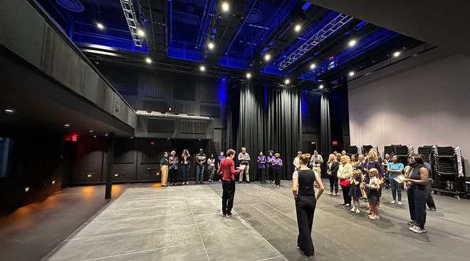 Guests on a tour of the new Booker High Visual and Performing Arts Center, stop to hear about the 125-seat, Black Box Theater flexible performance space.