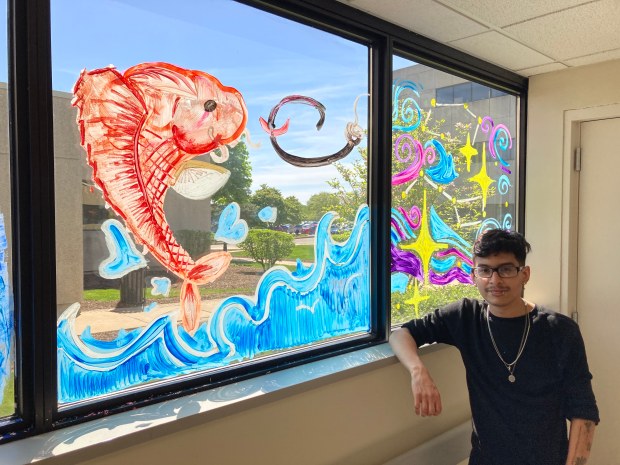 Bremen High School student Edgar Gonzalez, of Harvey, stands next a portion of a mural he painted Wednesday, May 1, at Advocate South Suburban Hospital in Hazel Crest in honor of Nurse Appreciation Week. 