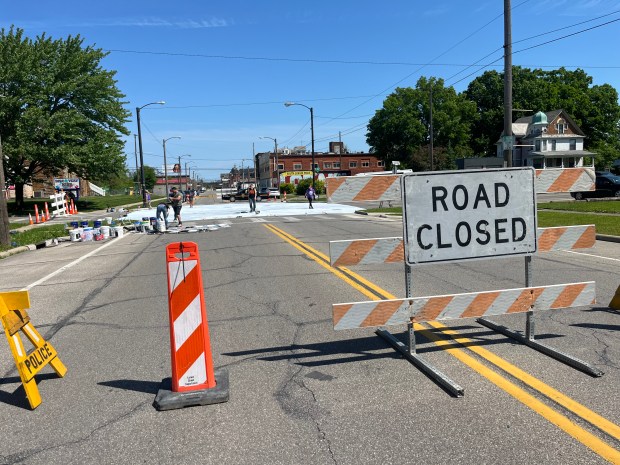 The FireFish Arts team and workers from the city of Lorain prepped the intersection of E 31st St. and Pearl Ave. for its new art mural on May 13. (Martin McConnell -- The Morning Journal)