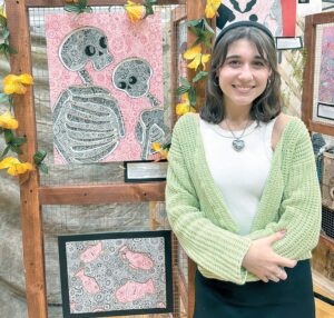 Ali Sierazy holding her two pieces of artwork she created for the April 25 IB art show. CONRAD DYRKACZ/photo