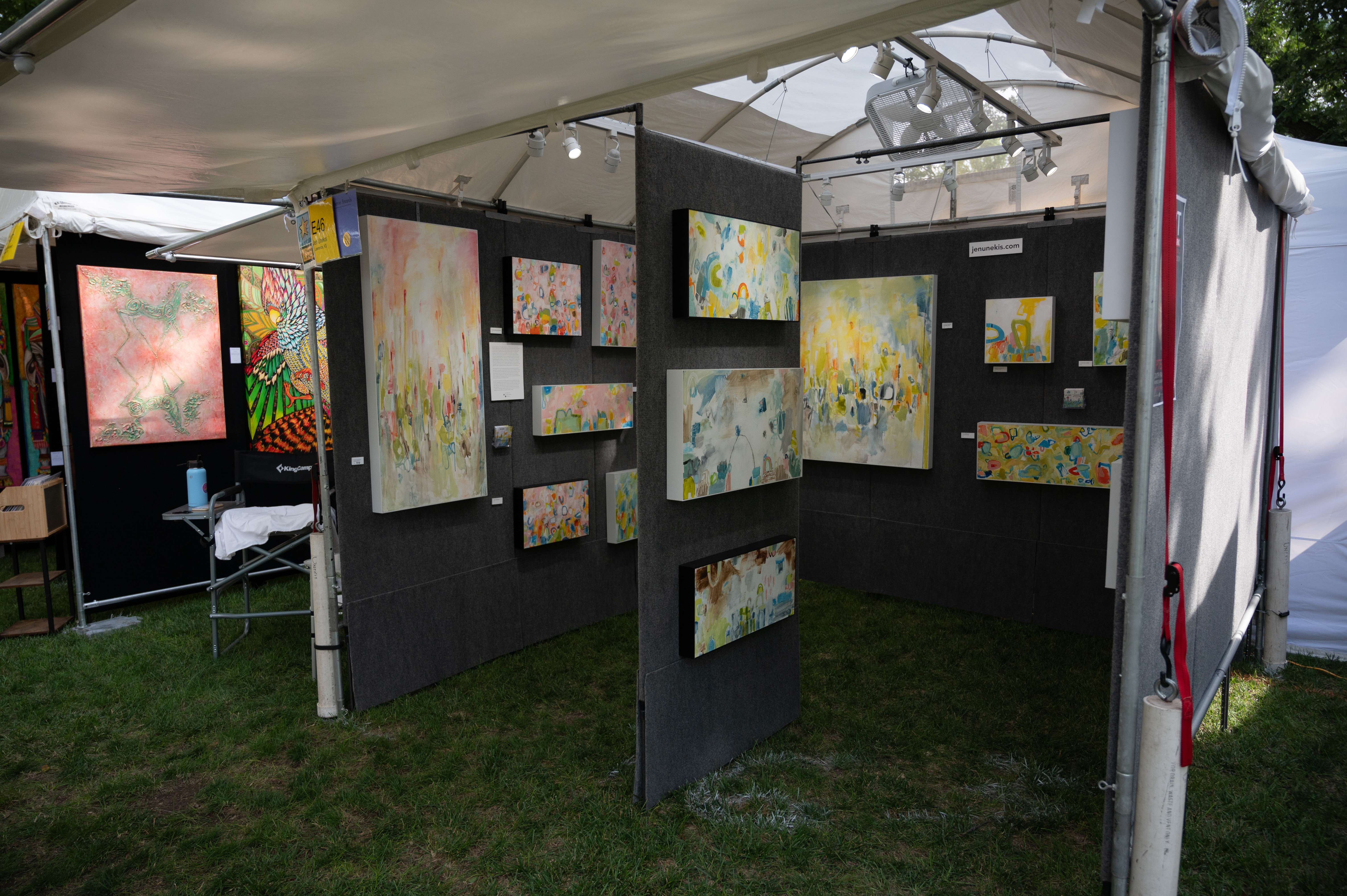 Jen Unekis, an artist from Lawrence, Kan., sits ready for customers to browse and buy her abstract art on Friday, June 14, during the Smoky Hill River Festival at Oakdale Park in Salina. <b>Photo by Olivia Bergmeier</b>