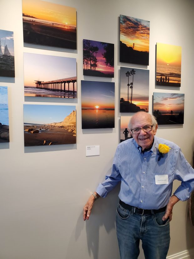 Artist David Janowsky stands with his photos of La Jolla...