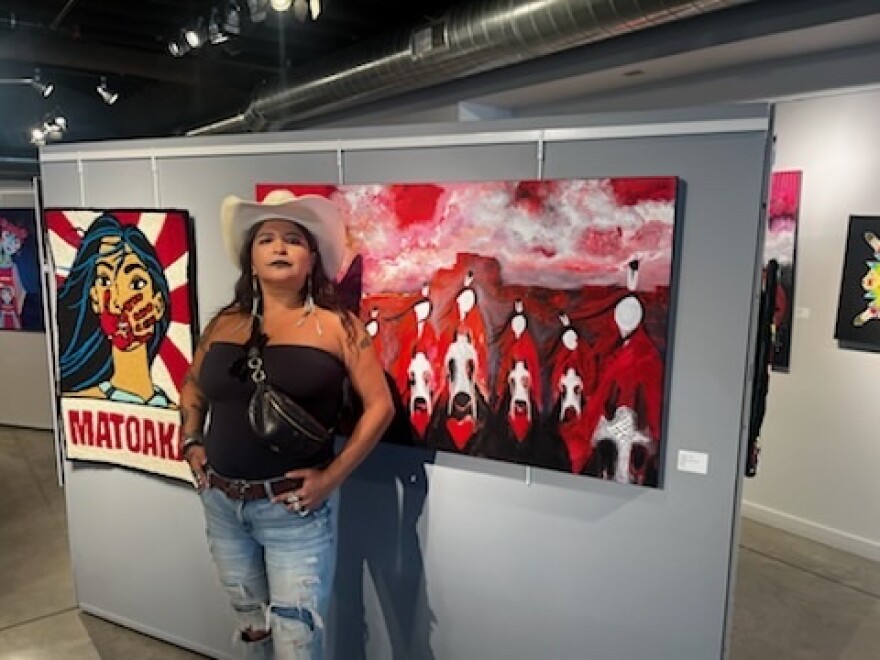 White stands with her painting "The Real Blood Tribe"